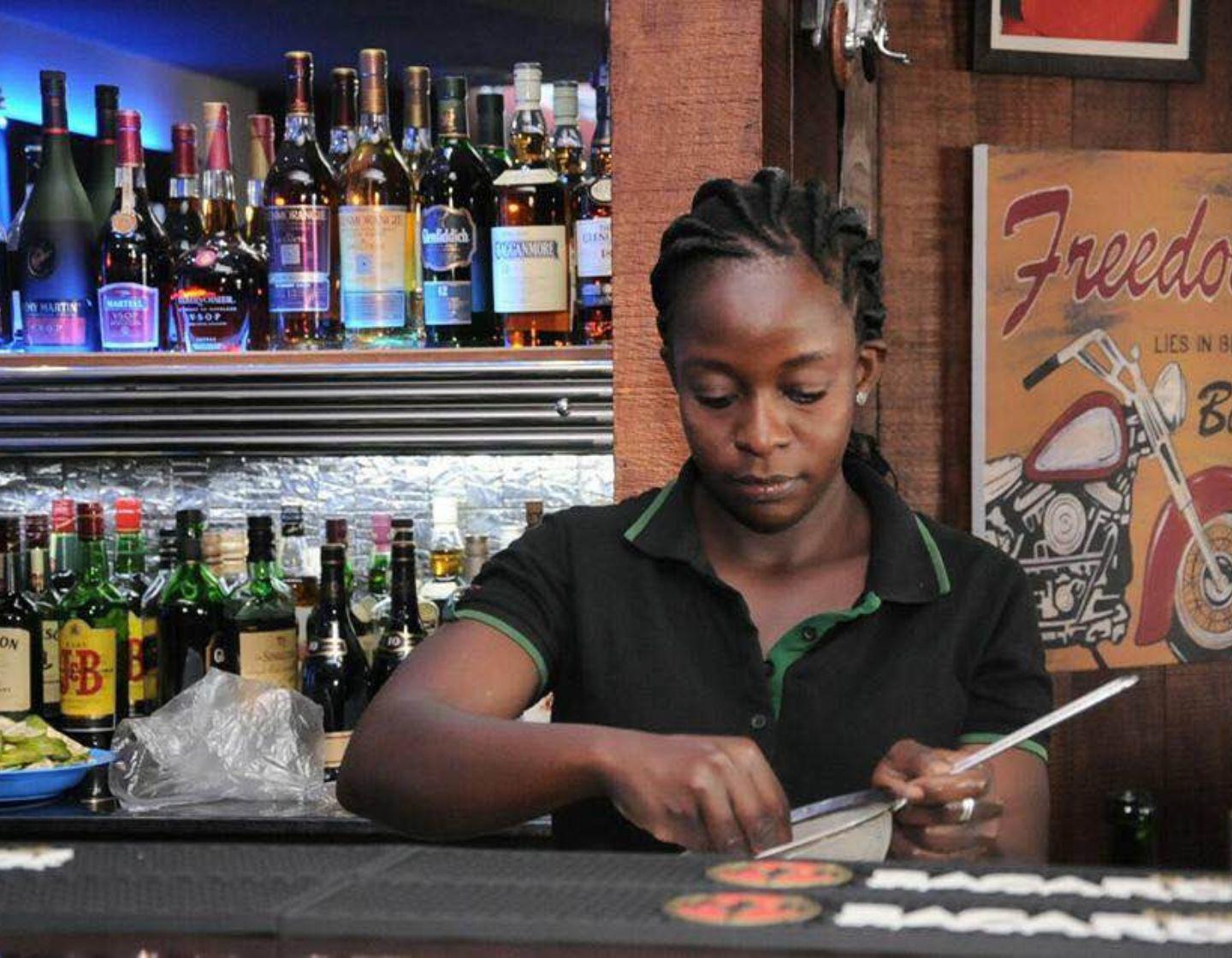 Bartender straining ice behind the bar