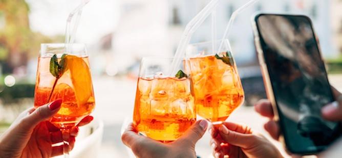 Cóctel en una copa tipo coupé con hielo, rodeado de una botella de Johnnie Walker Black Label Whisky, una coctelera y una cucharilla de bar.