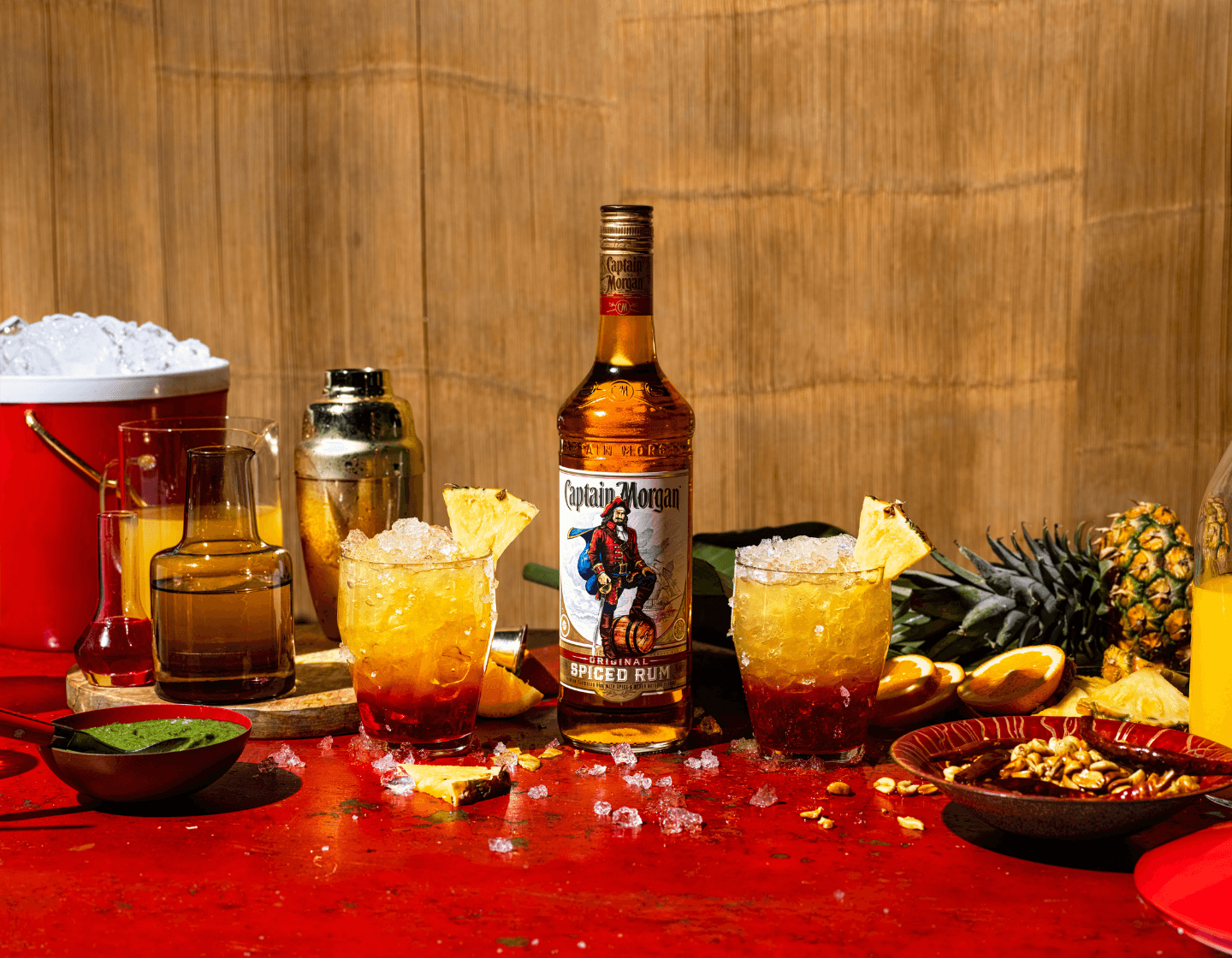Bottle of CÎROC on table beside cocktail glass and assorted plates of food 