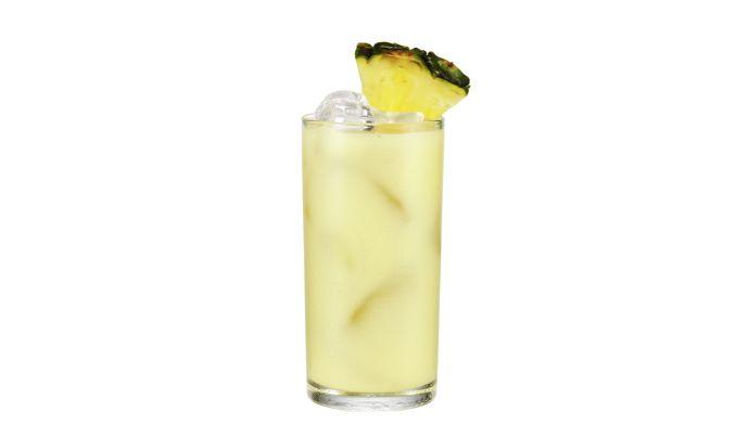 Cuban breeze cocktail on a black background by a pineapple