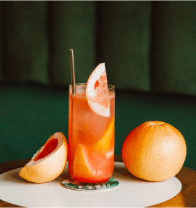 Cóctel con sabor a pomelo adornado con una rodaja de pomelo