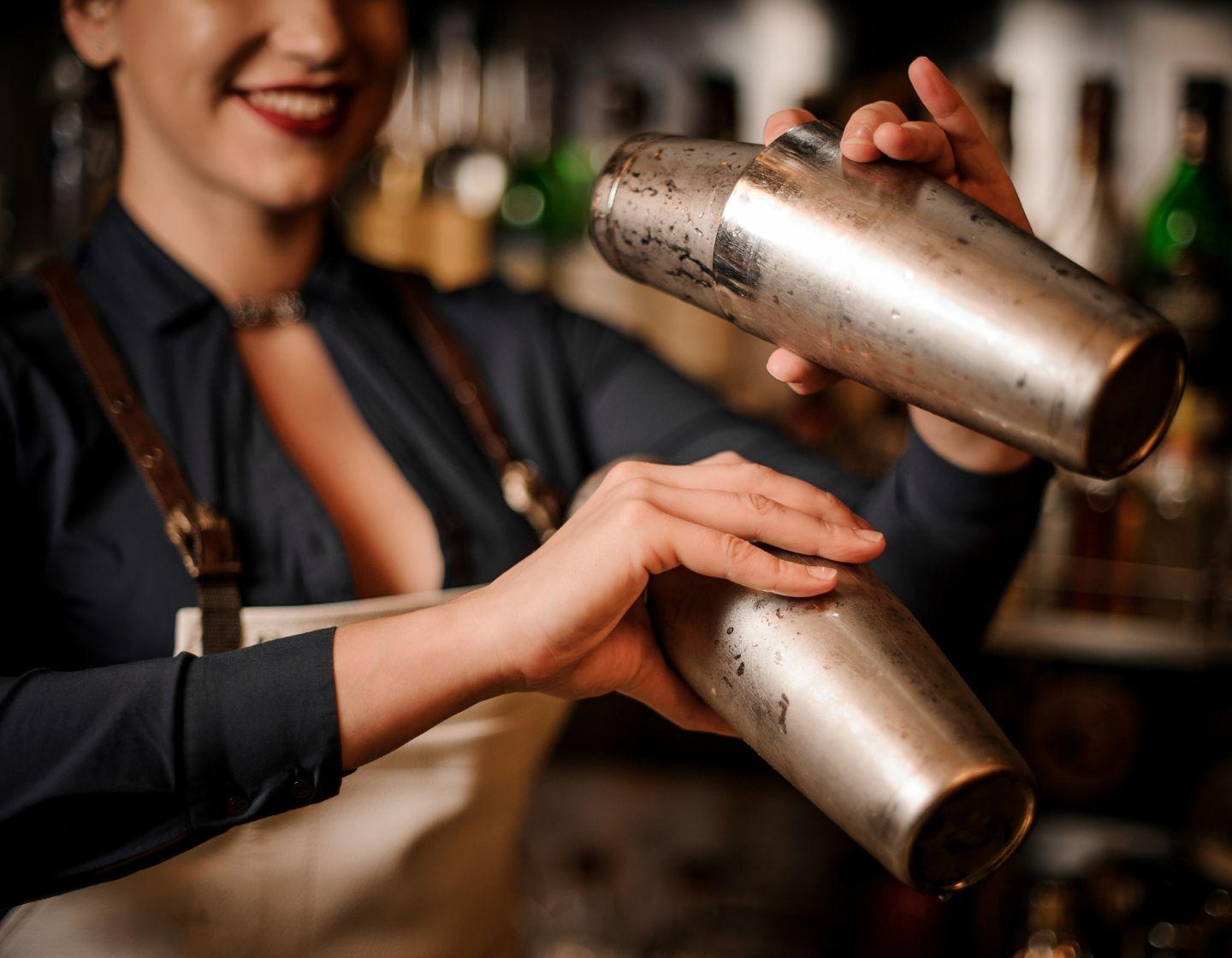 female bartender shaking cocktails
