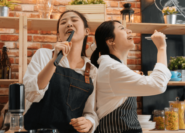 Imagem de duas mulheres dançando e cantando
