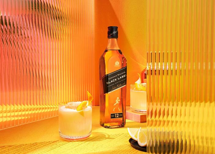 Bottle of Johnnie Walker Blakc Label with two glasses of cocktail