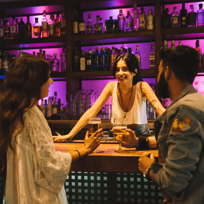Bartenders atendiento en un bar lleno de gente