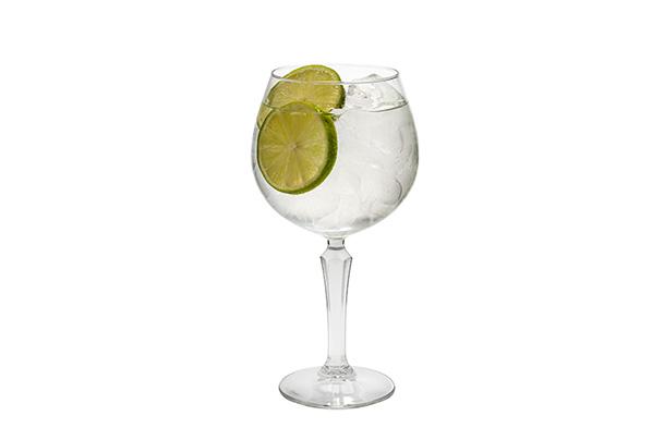 Cocktail in a wine glass with lime garnish