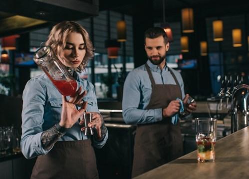 Zwei Barkeeper mixen einen Drink