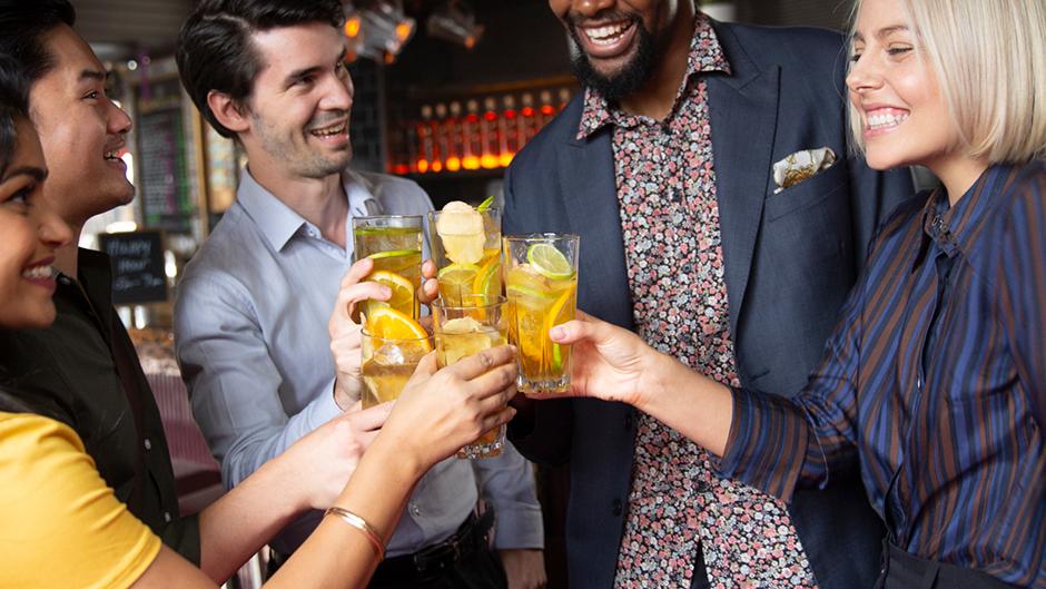 Bar patrons cheering with a cocktail