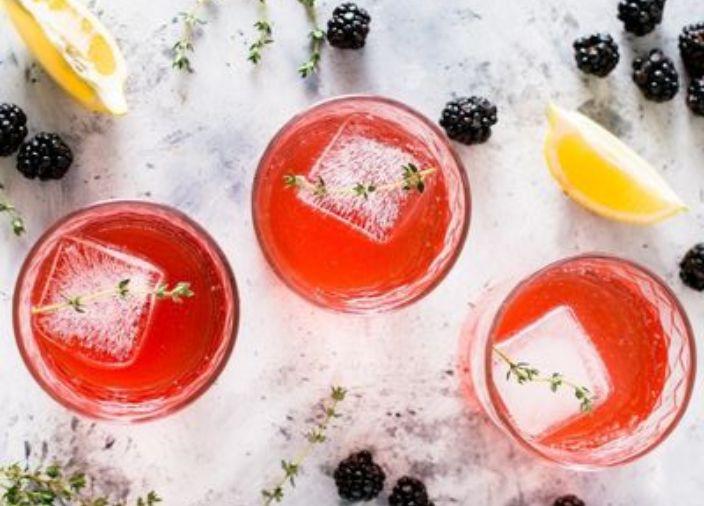 Three orange cocktails with lemons and mixed fruit.