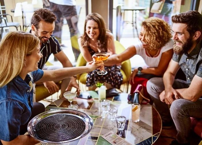 Imagem de pessoas em um bar celebrando