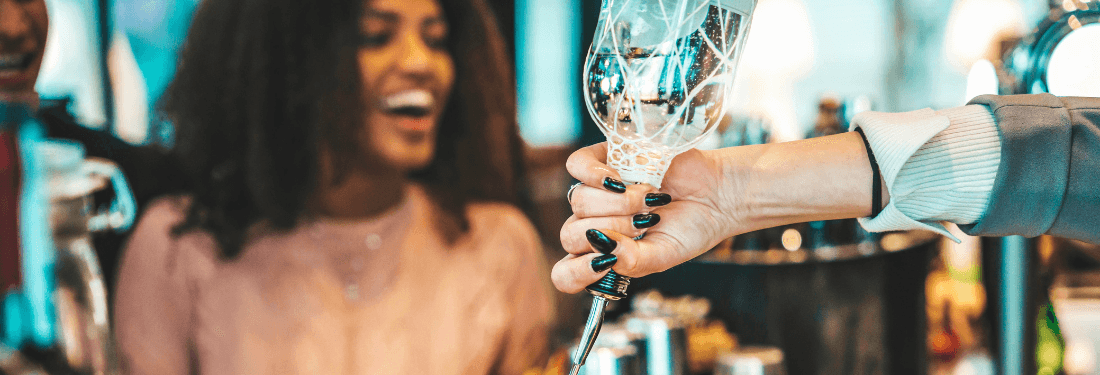 Bartender sirviendo un trago a un cliente satisfecho