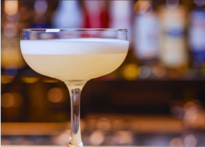 peach coloured cocktail with foam 
