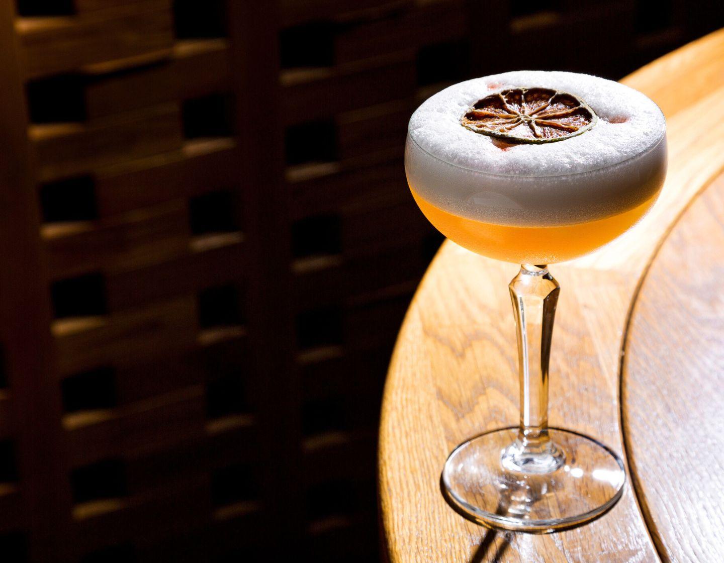 Cocktail foam with dried orange garnish.