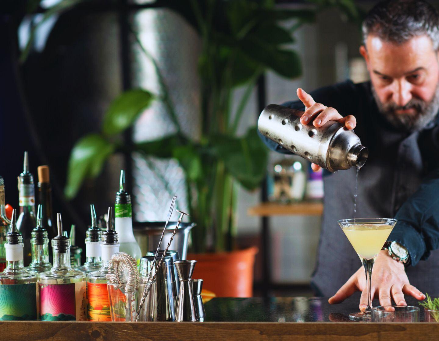 Bartender sirviendo coctel despues de agitar