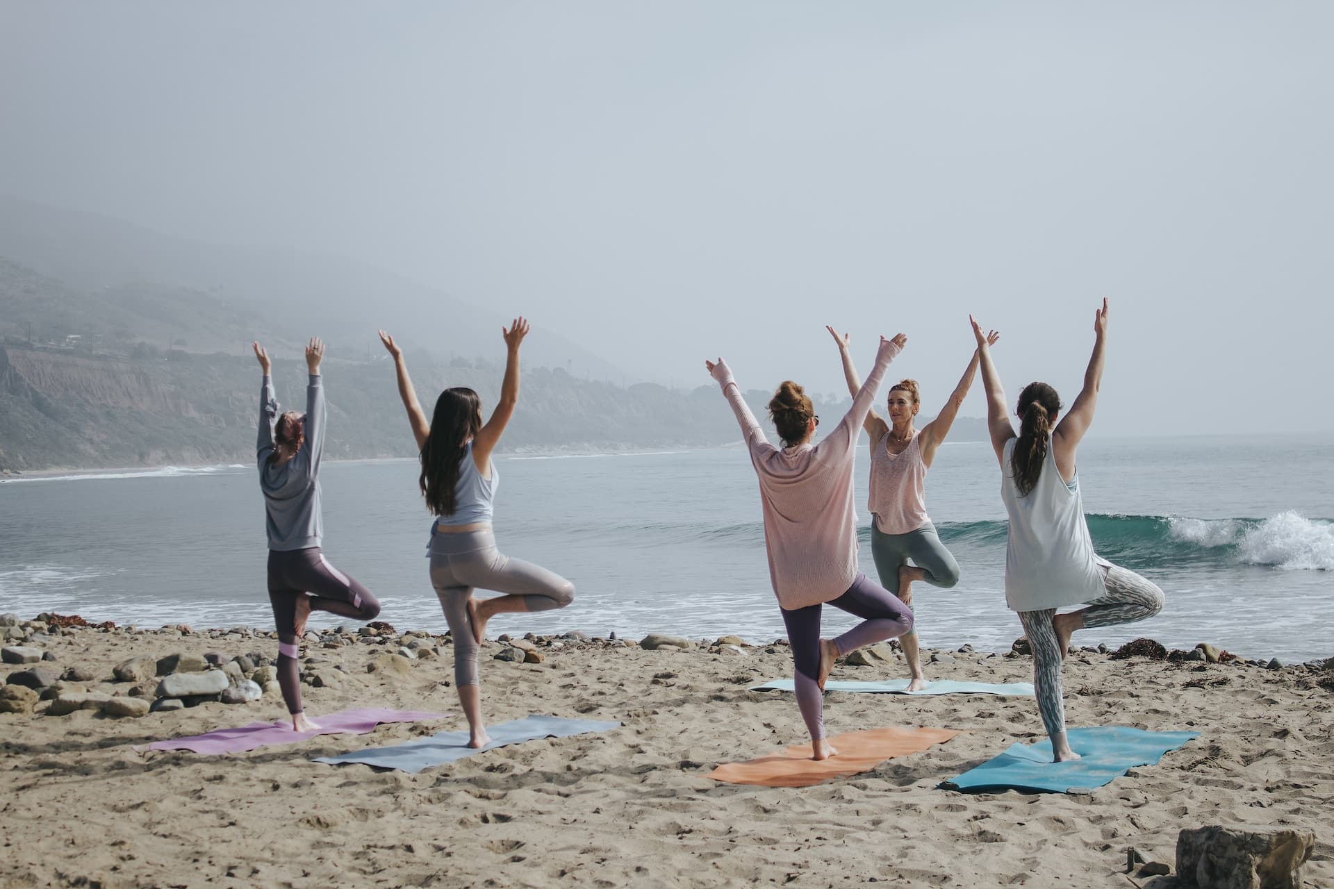 A group of people practicing yoga on the beach 