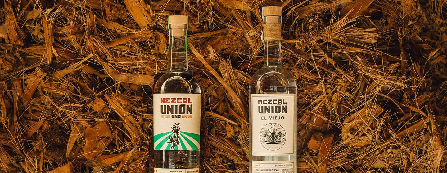 Two Mexcal Union bottles in a barrel