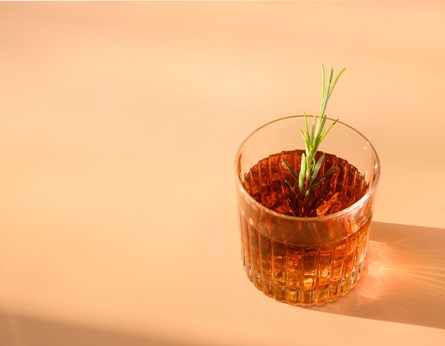 Whiskey cocktail garnished with sprig.