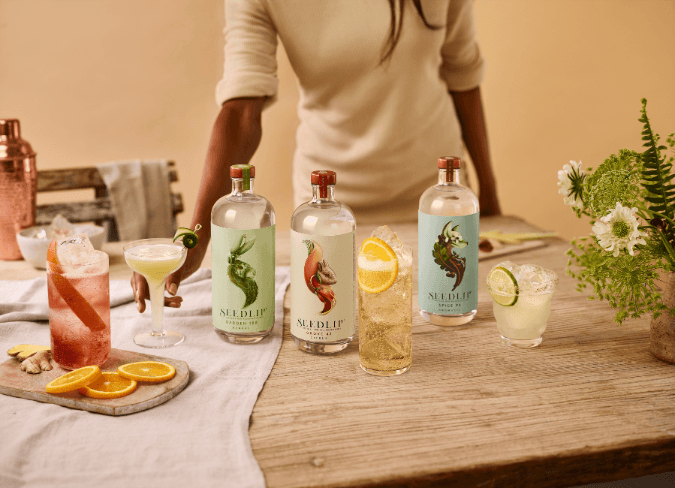 Selection of Seedlip bottles on table surrounded by assorted cocktails