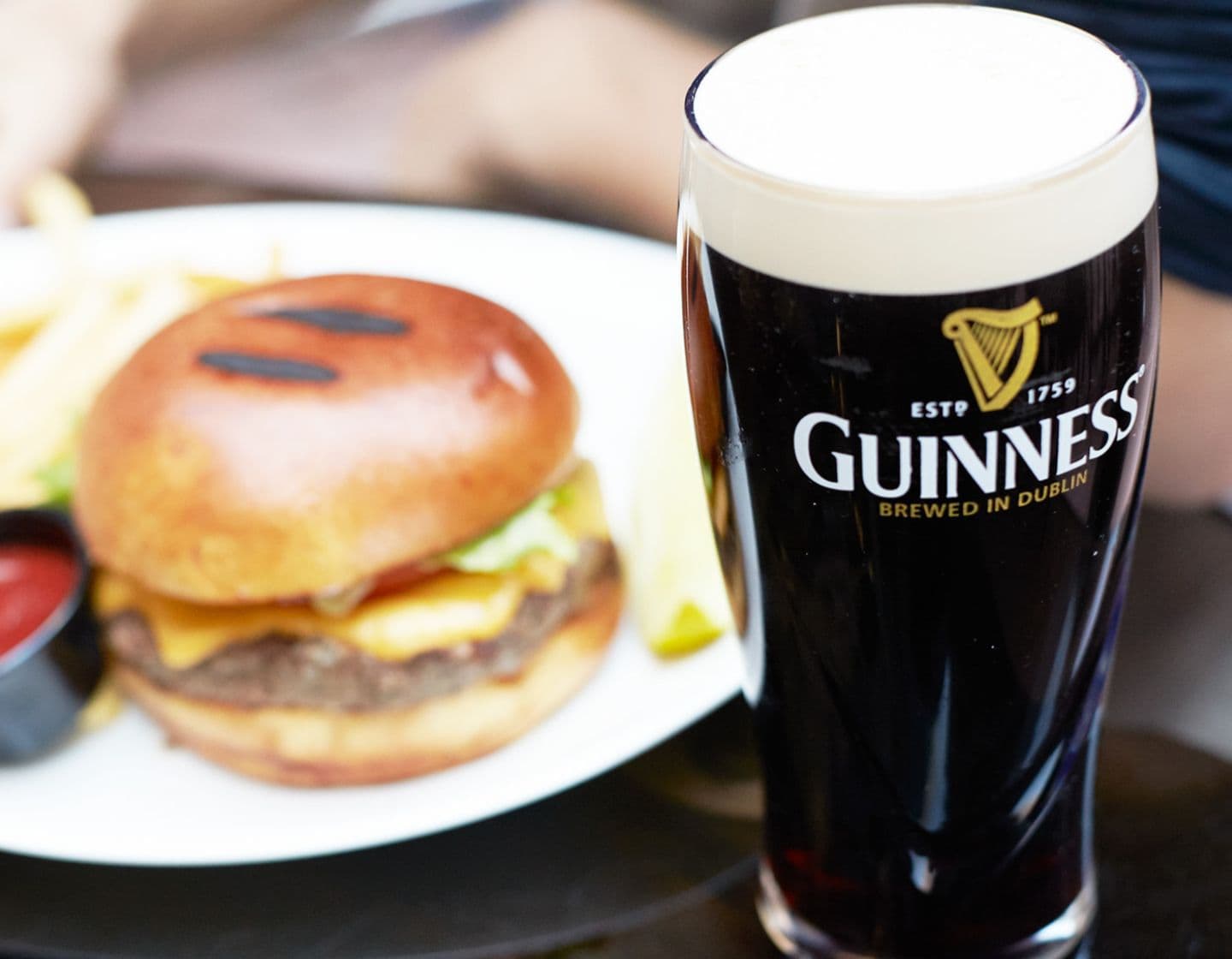 A pint of Guinness next to a burger  