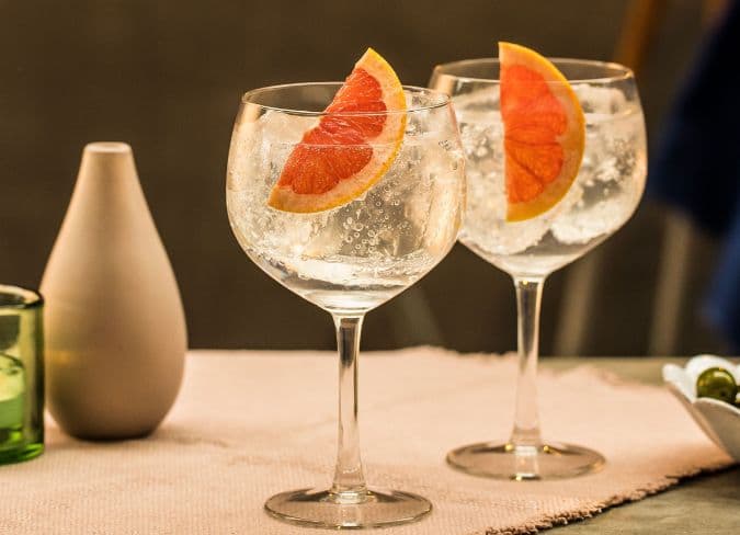 Two gin cocktails garnished with grapefruit slices