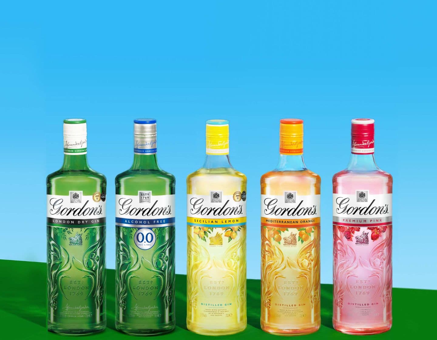 Selection of Gordon’s gin bottles on a blue and yellow background 