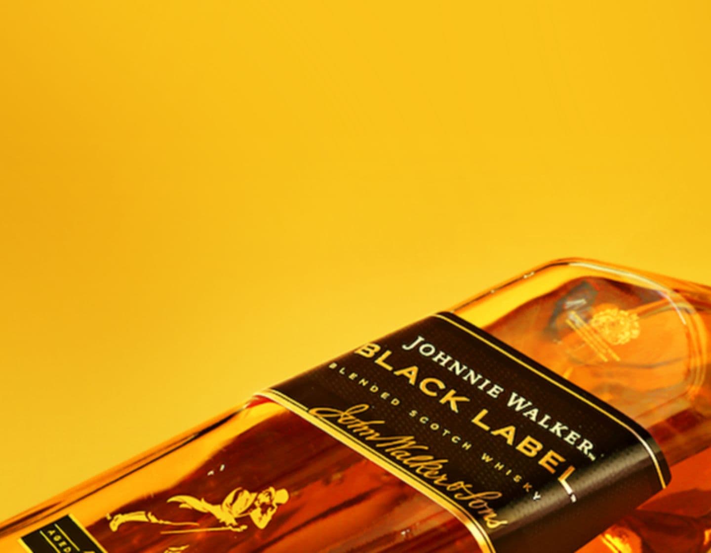 Close-up shot of Johnnie Walker Black Label against a yellow background 