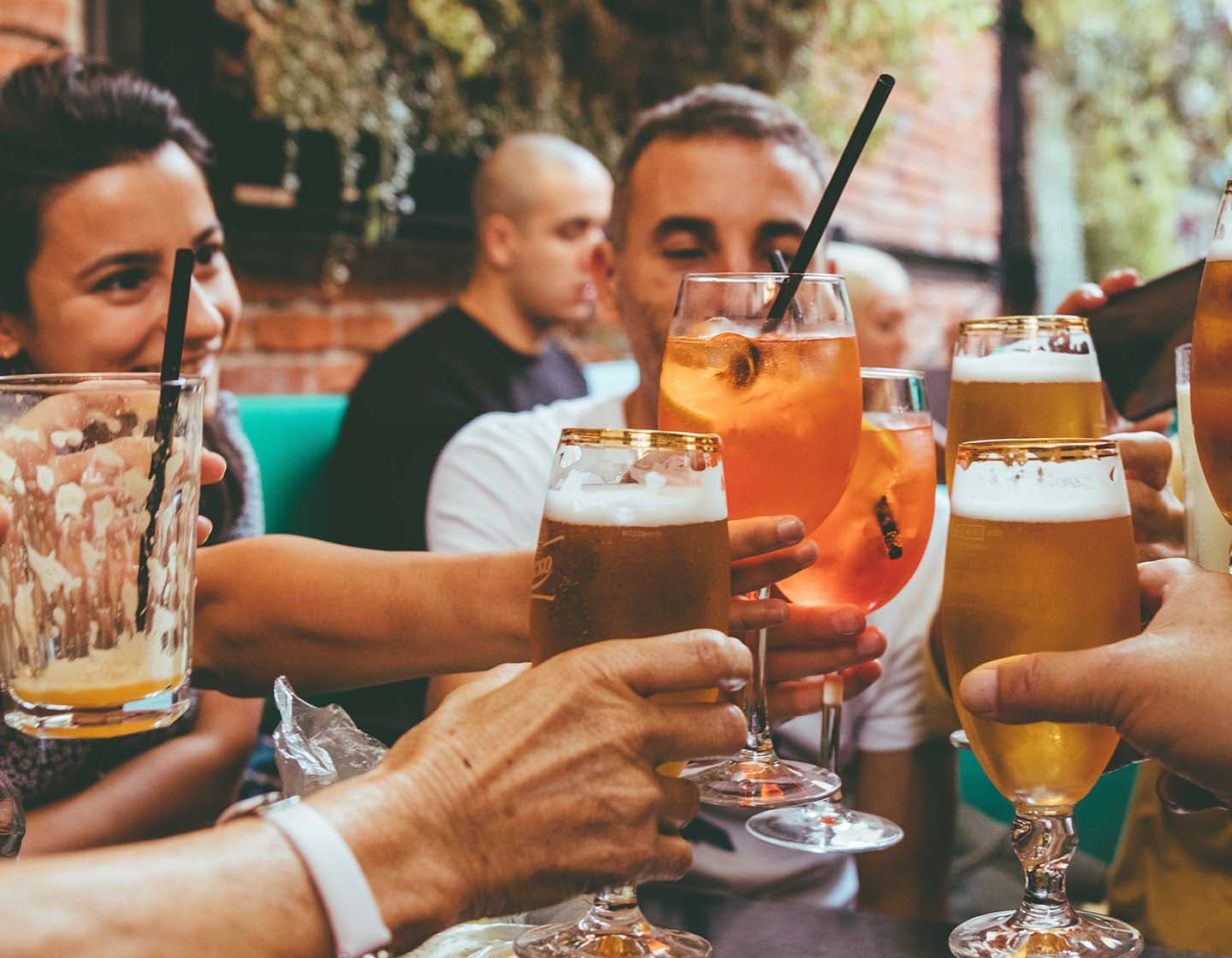 Grupo de convidados brindando com seus copos em um bar