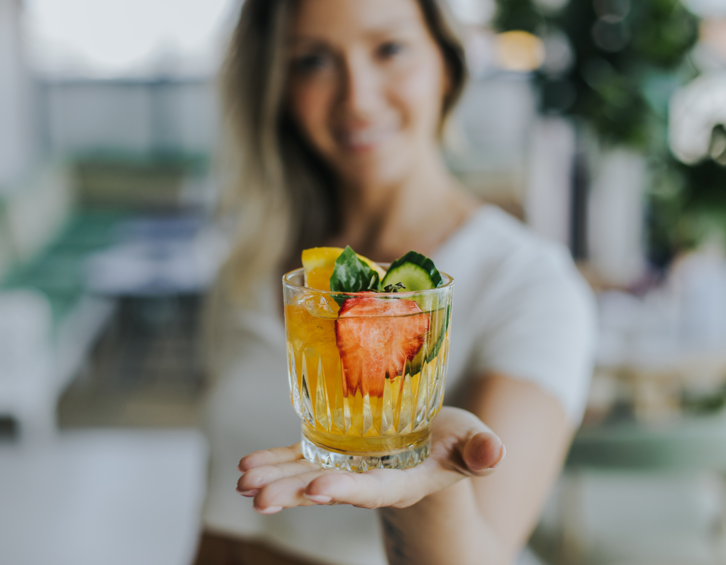 Woman holding drink filled with fruits