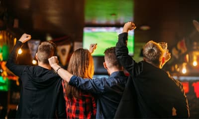 Imagem torcedores assistindo jogo de futebol no bar 