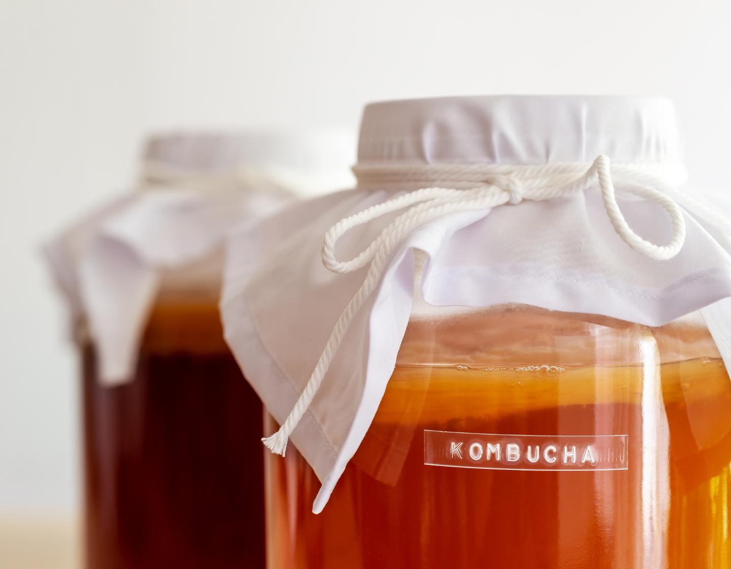 Jars of kombucha with fabric lids