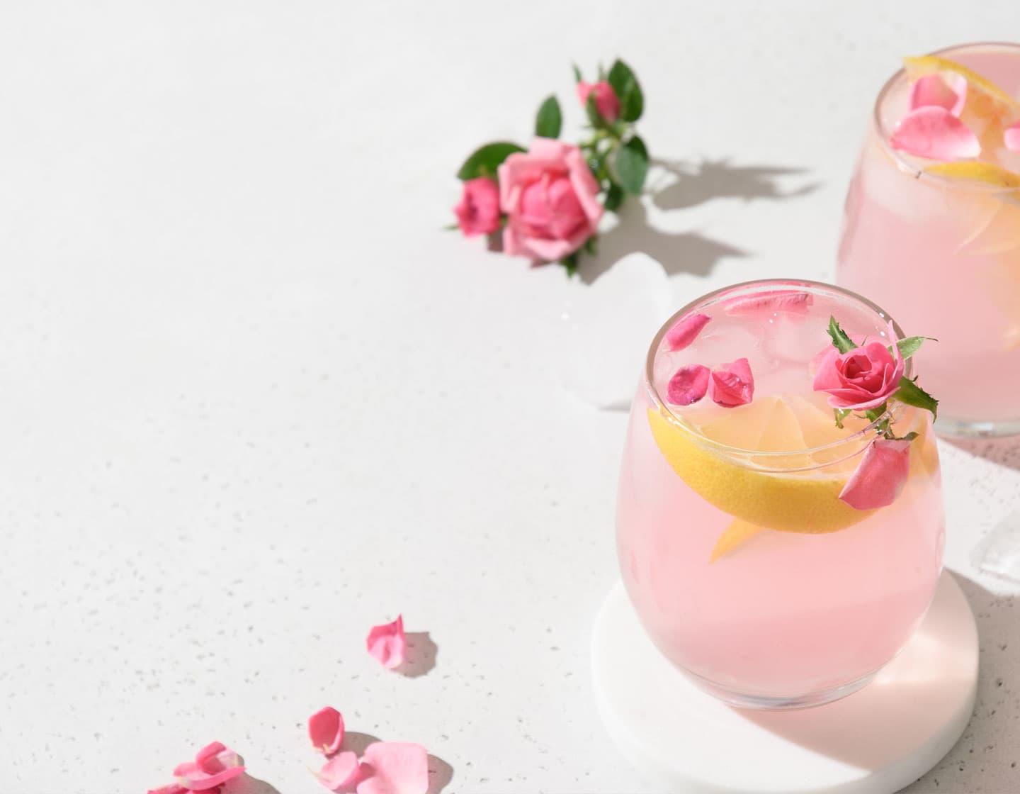 2 glasses of pink cocktails with roses