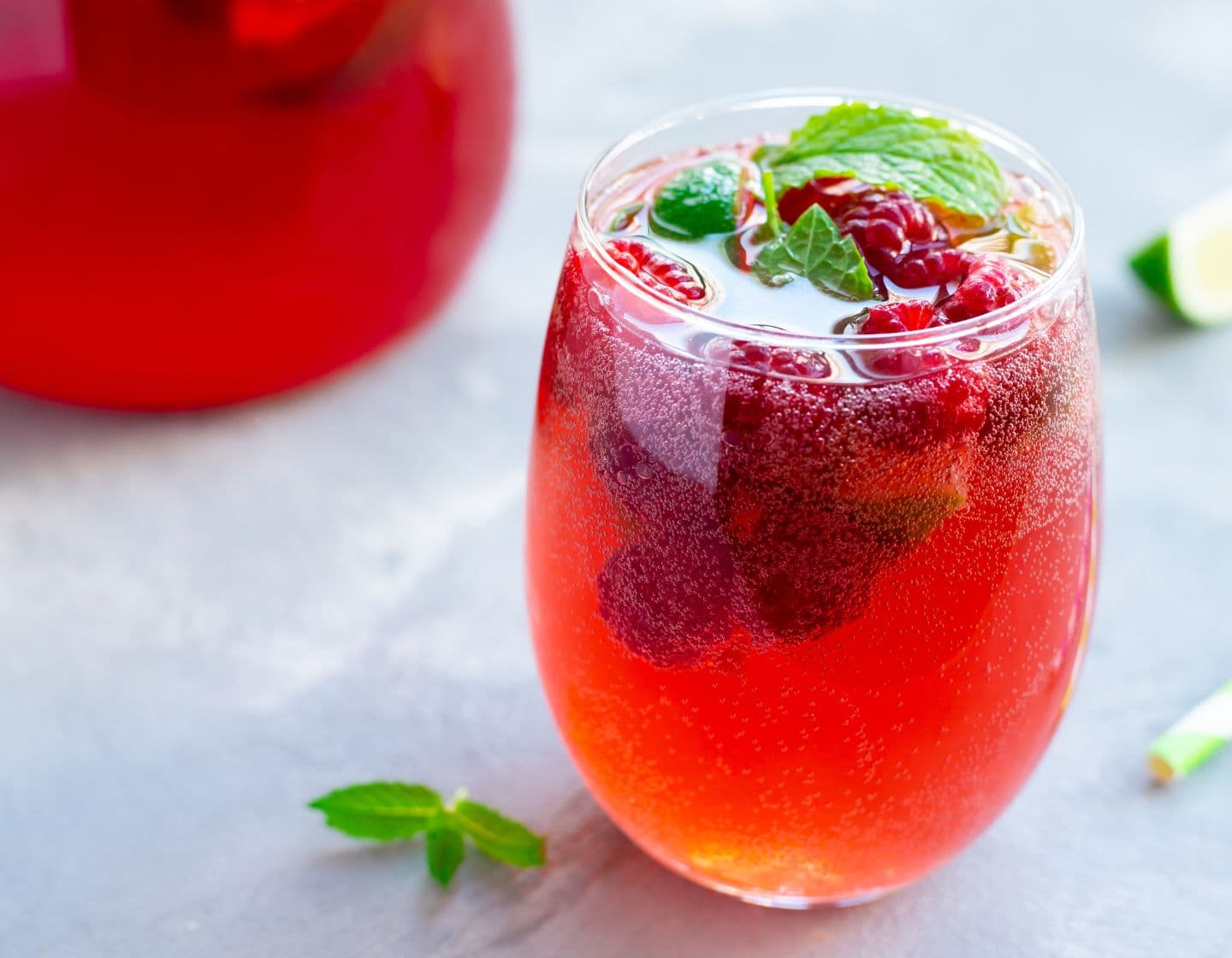 Carbonated cocktail of red colour with raspberry garnish    