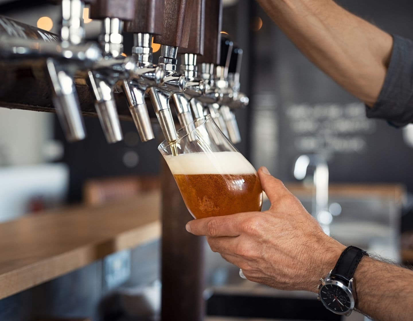 Ein Barkeeper zapft ein Pint Bier vom Fass.