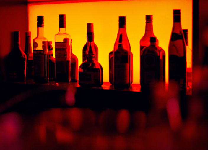 Eine Reihe Flaschen in einer dunklen Bar. 