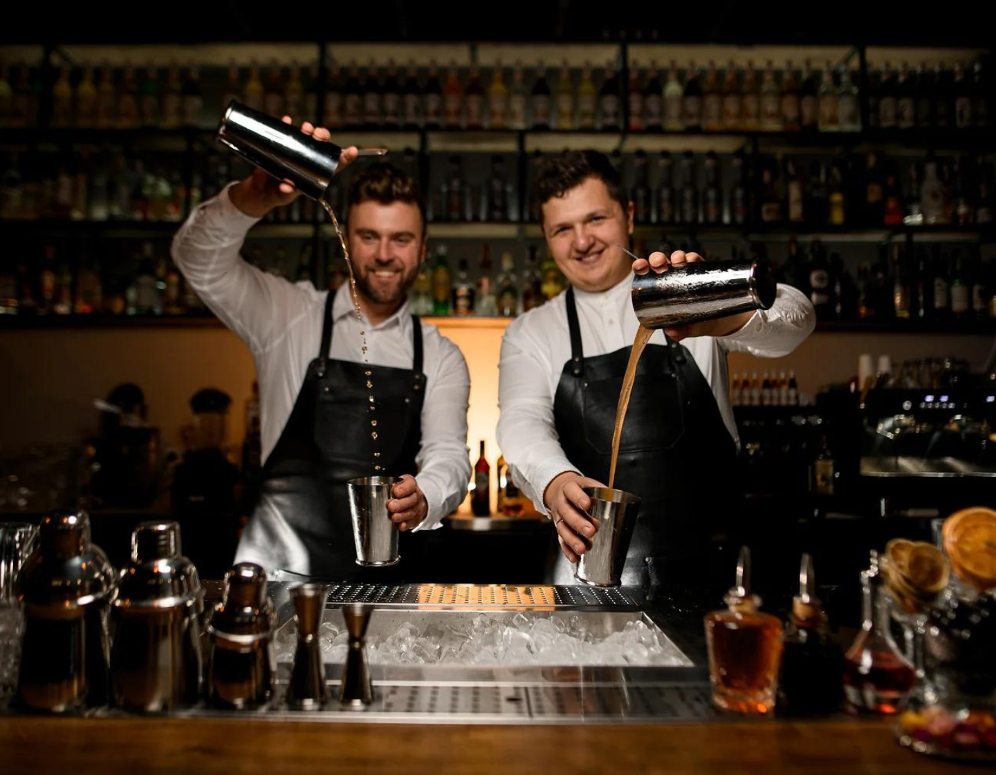 Two bartenders with cocktail shakers 