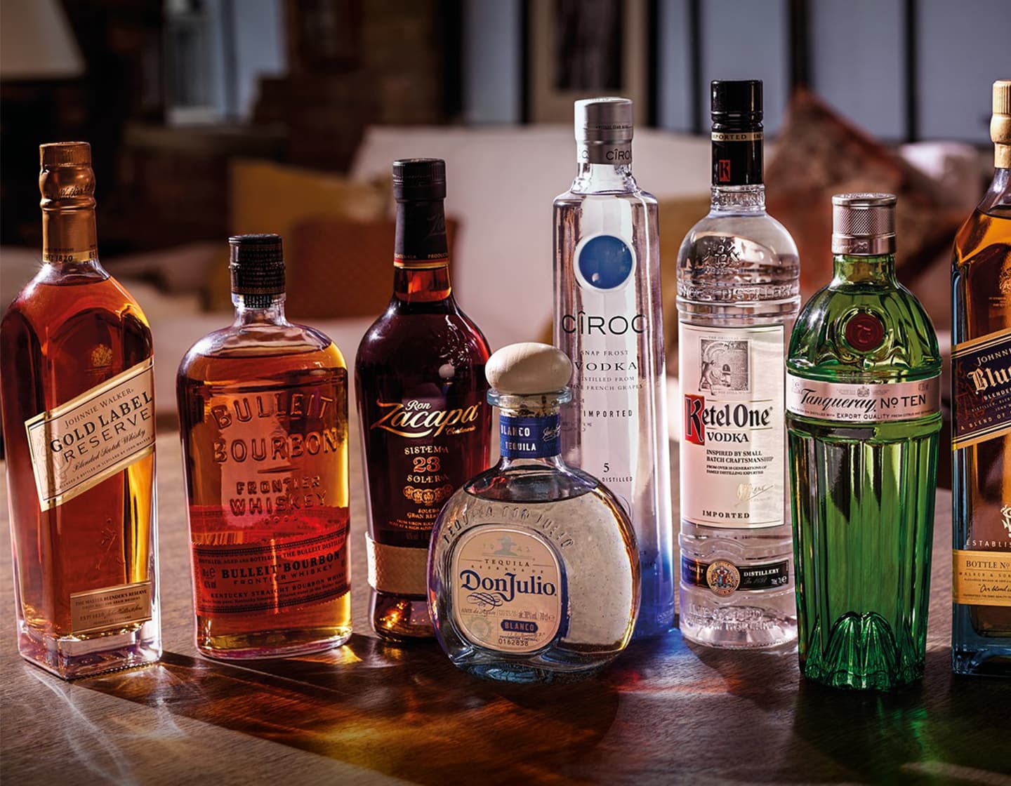 Eine Gruppe von Flaschen mit Alkohol, von links nach rechts: Johnnie Walker Gold Label Reserve, Bulleit Bourbon, Zacapa, Don Julio, Cîroc, Ketel One, Tanqueray No Ten und Johnnie Walker Blue Label. 