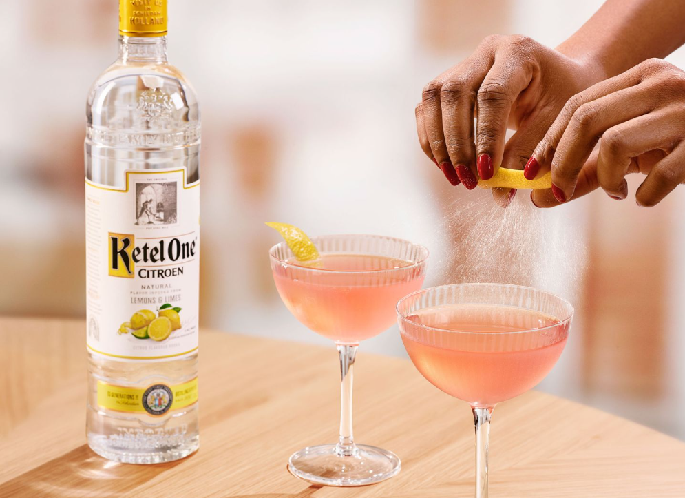 Dos cócteles de vodka rosa con garnish de limón.