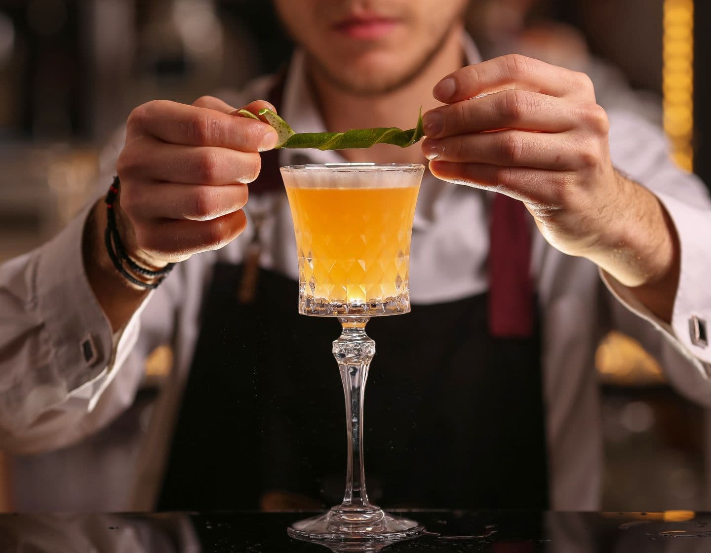Bartender adding a lime garnish to a cocktail 
