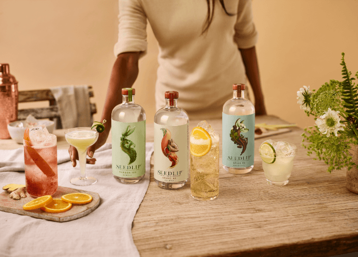 Selection of Seedlip bottles on table surrounded by assorted cocktails