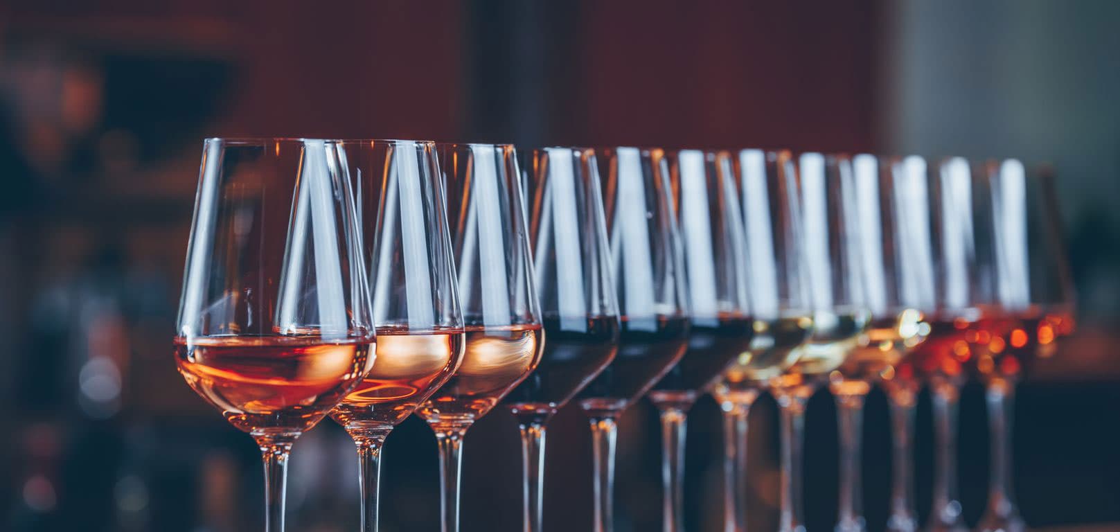 a row of glasses of different coloured wines
