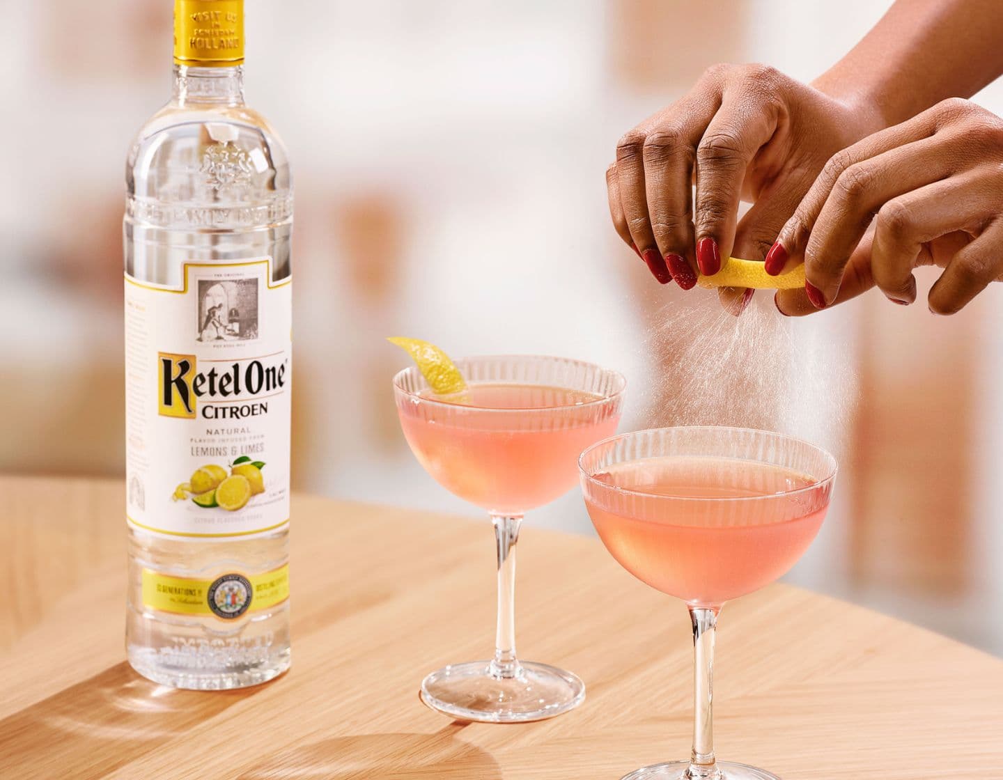 Pink Vodka cocktail with lemon garnish.