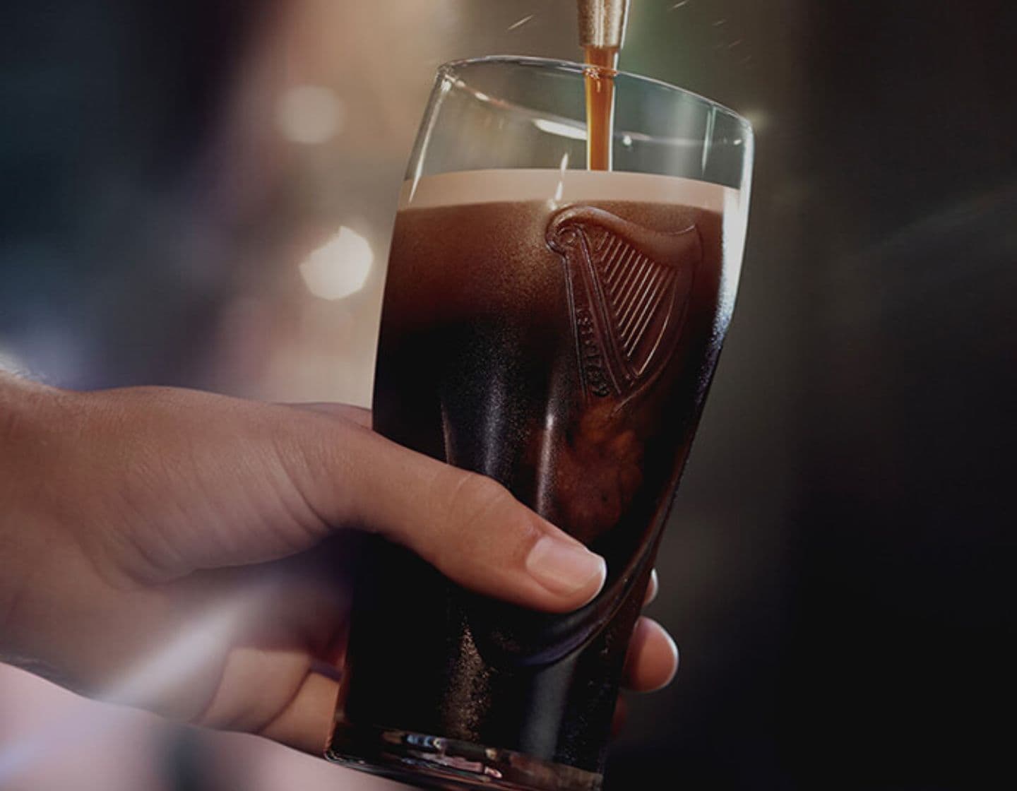 Una lata de cerveza Guinness junto a un vaso de pinta. 