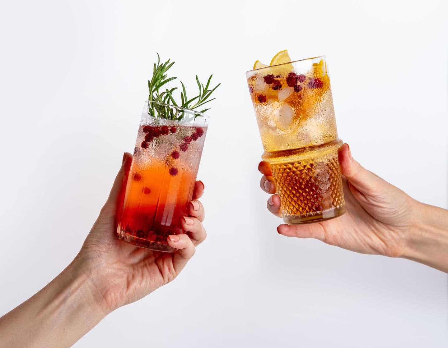 Two highball cocktails being clinked together to cheers 