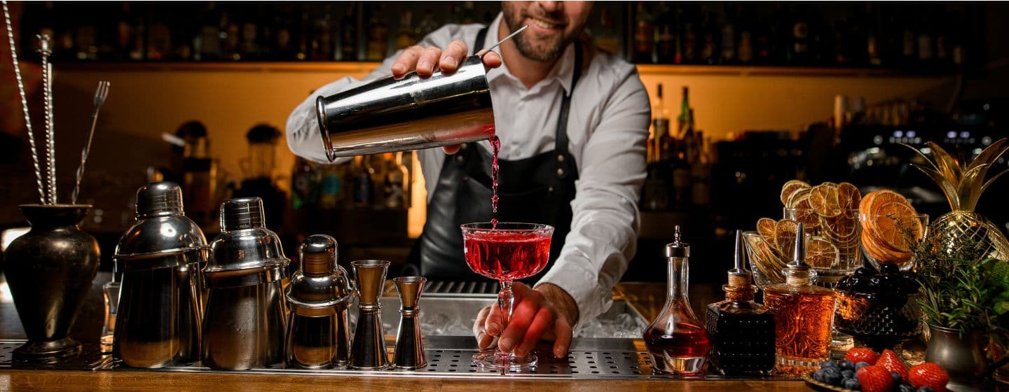 Imagem de um bartender fazendo um drink no bar 