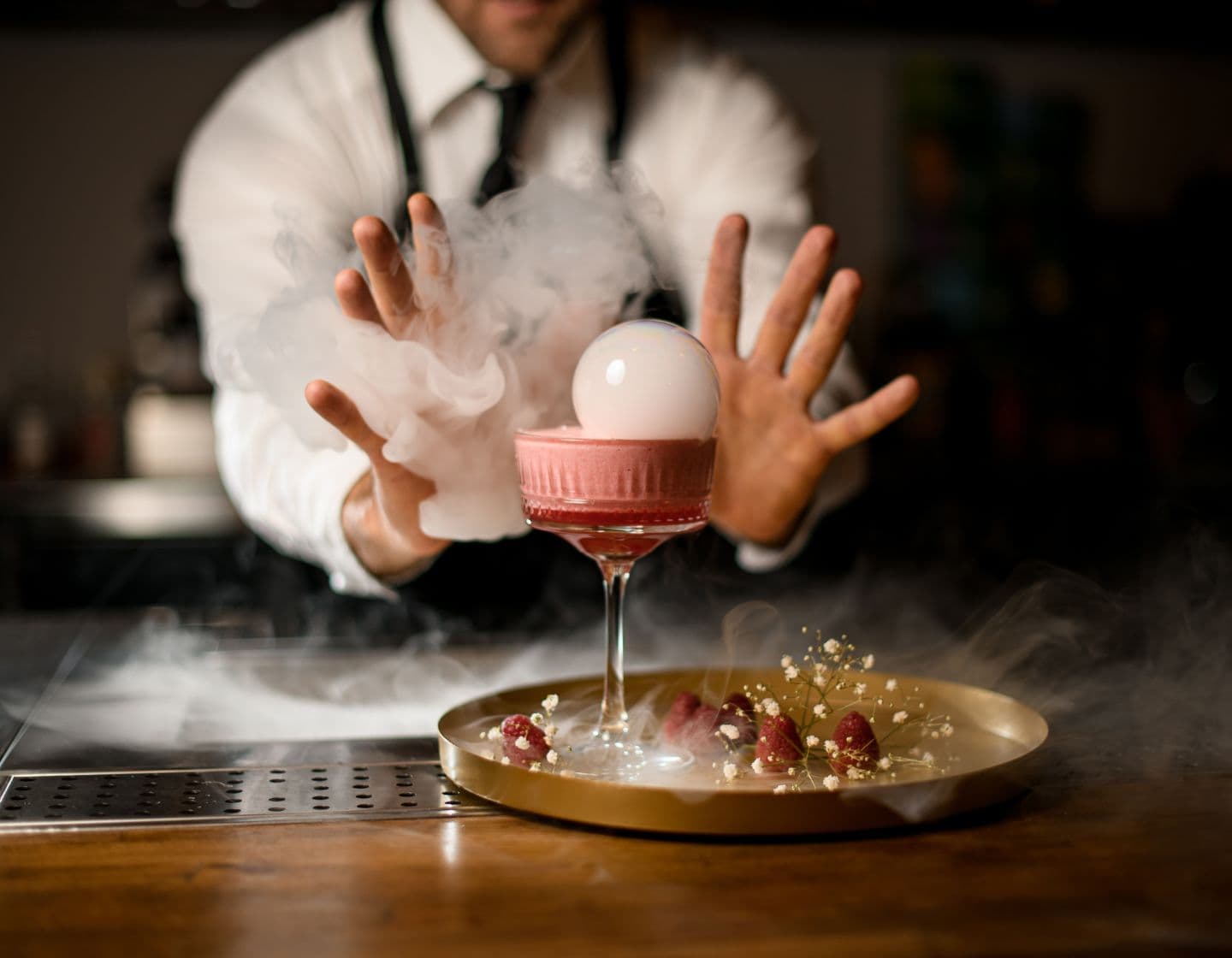 Barkeeper gestaltet einen Cocktails mit einer Rauchwolke 
