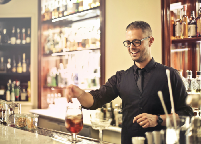 Smiling bartender preparing drink 