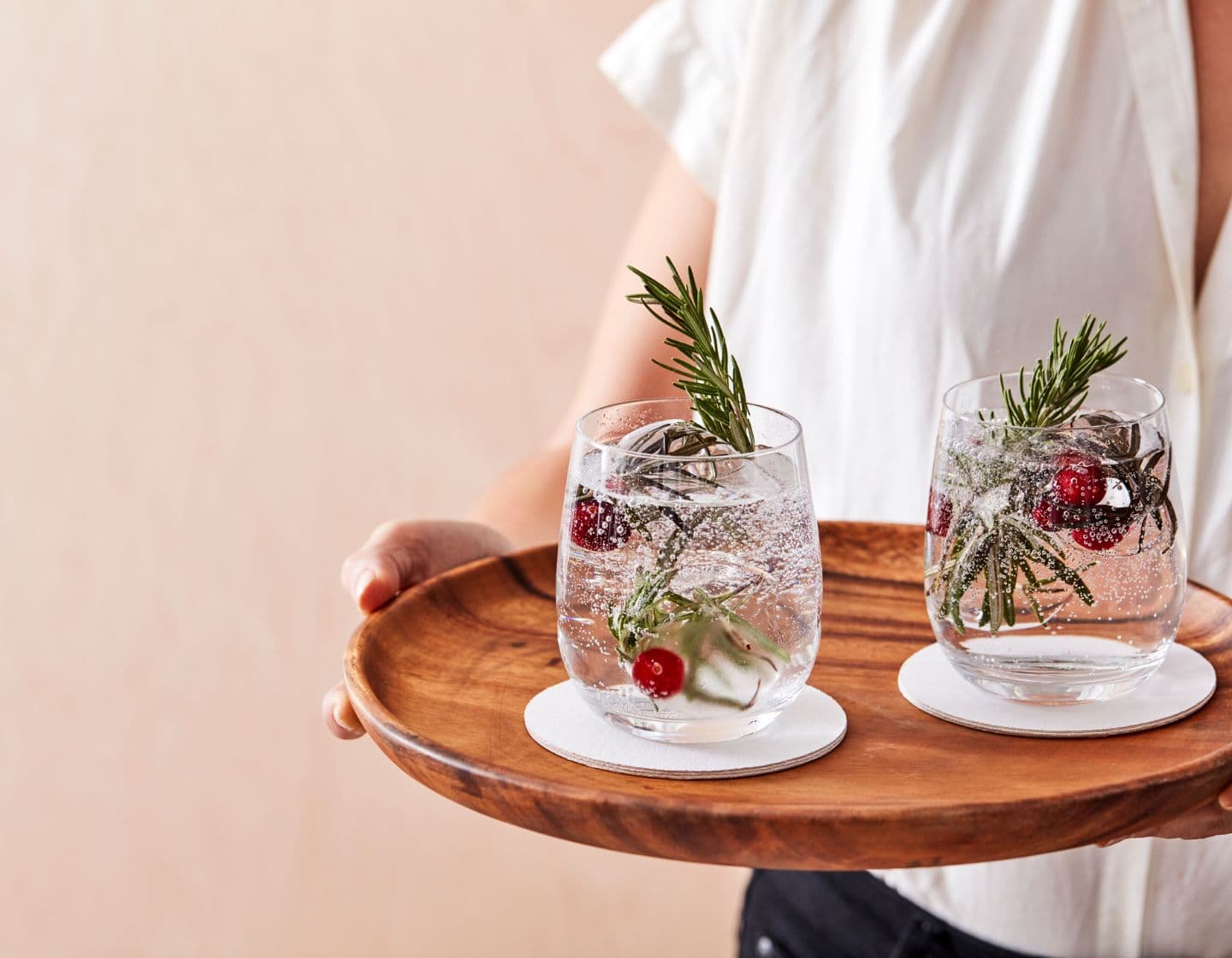 Zwei nachhaltige und durchsichtige Cocktails werden auf einem Holztablett serviert