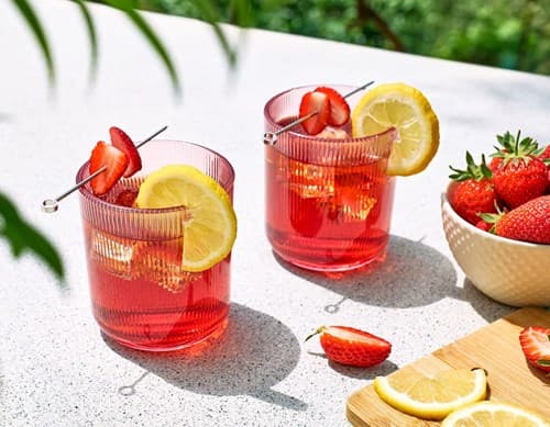 Dos cócteles con fresas y decoración de limón. 
