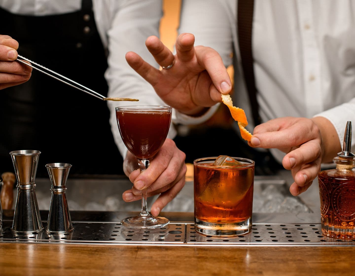 bartenders adding garnish to cocktails